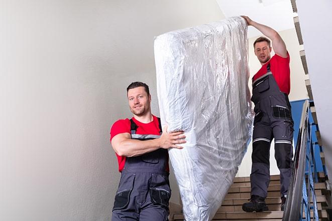 a heavy box spring being carried out of a house in Escatawpa